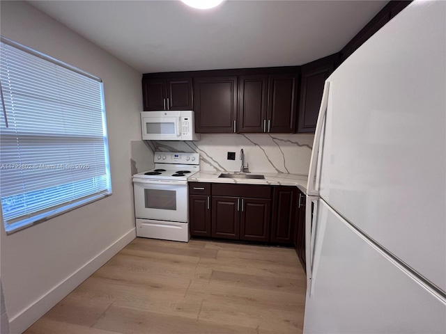 kitchen with white appliances, light wood-type flooring, sink, and dark brown cabinetry