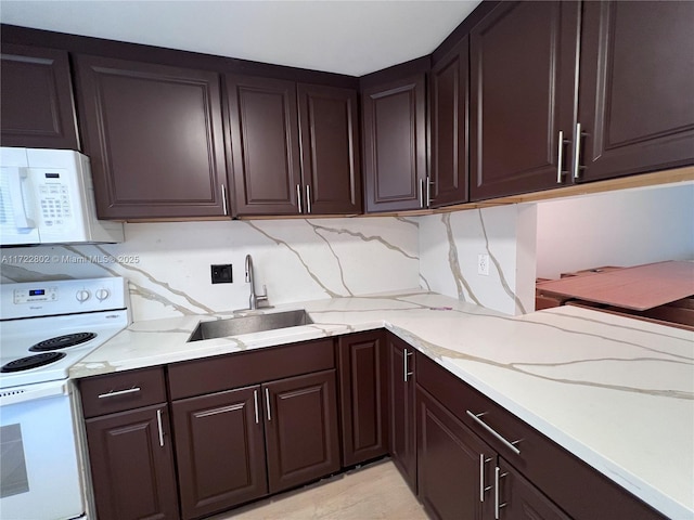 kitchen featuring white appliances, dark brown cabinets, and sink