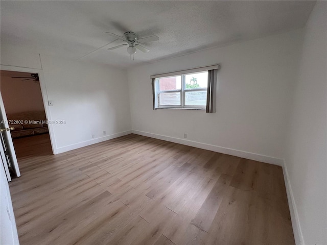 spare room featuring a textured ceiling, ceiling fan, and light hardwood / wood-style flooring