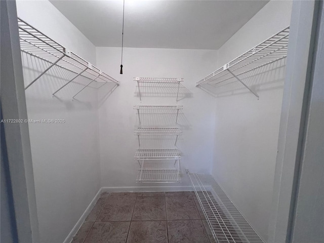 spacious closet with dark tile patterned floors