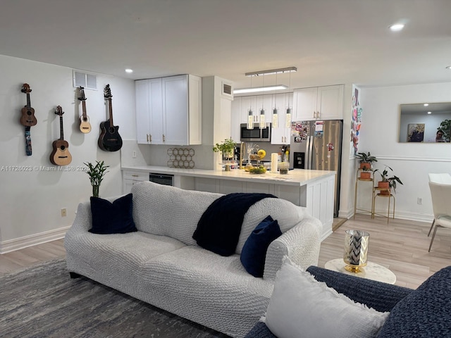 living area with recessed lighting, baseboards, visible vents, and light wood finished floors