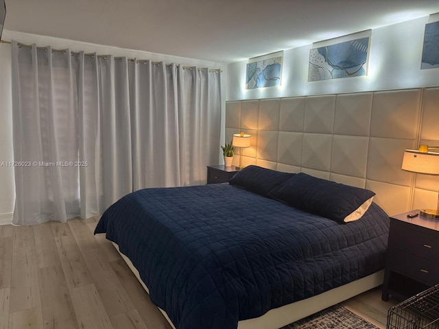 bedroom with tile walls and light hardwood / wood-style flooring