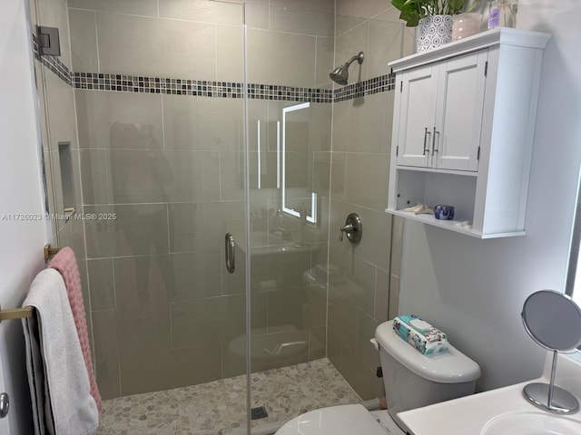 bathroom with toilet and a shower with shower door