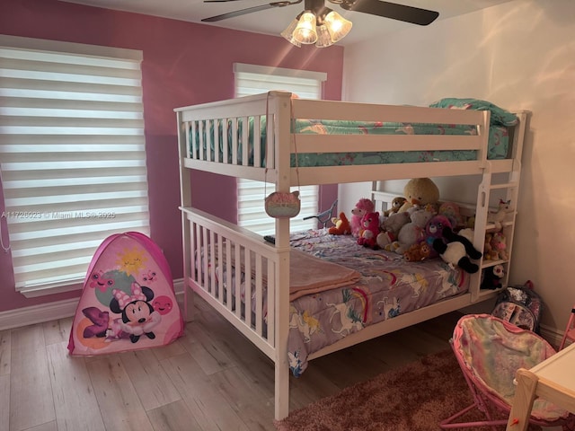 bedroom featuring hardwood / wood-style flooring, ceiling fan, and multiple windows