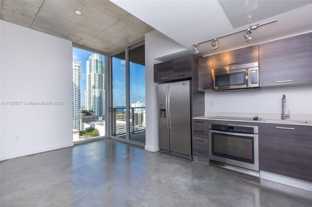 doorway to outside featuring a healthy amount of sunlight, concrete flooring, and expansive windows