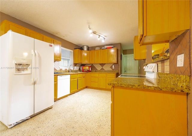 kitchen featuring decorative backsplash, sink, white appliances, and a textured ceiling