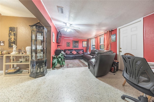 living room featuring ceiling fan, a textured ceiling, and lofted ceiling