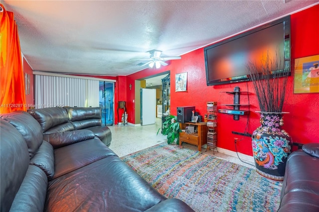 living room featuring ceiling fan and a textured ceiling