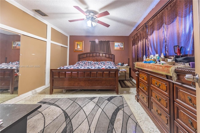 bedroom with ceiling fan, a textured ceiling, and ornamental molding