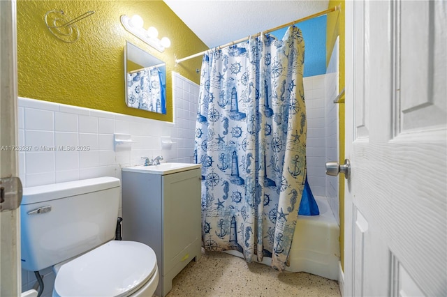 full bathroom with tile walls, toilet, vanity, and shower / tub combo with curtain