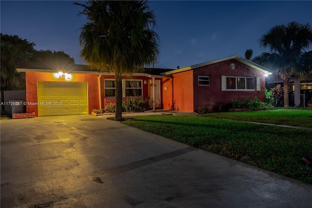 single story home with a garage and a lawn