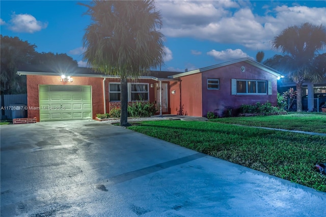 ranch-style home with a garage and a yard