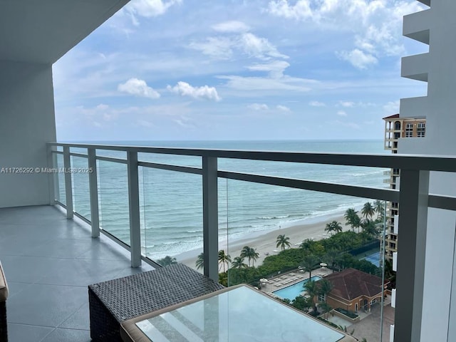 balcony featuring a view of the beach and a water view