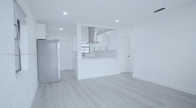 unfurnished living room with light hardwood / wood-style flooring and sink