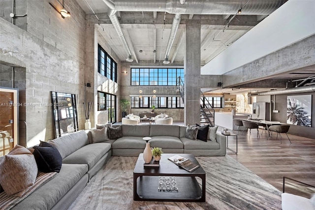 living room with a towering ceiling and wood-type flooring