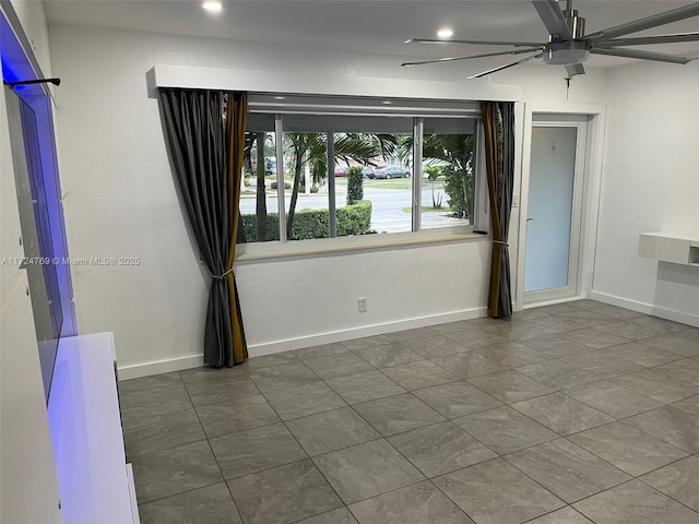 spare room with tile patterned floors and ceiling fan