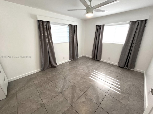 unfurnished room featuring a wealth of natural light and ceiling fan