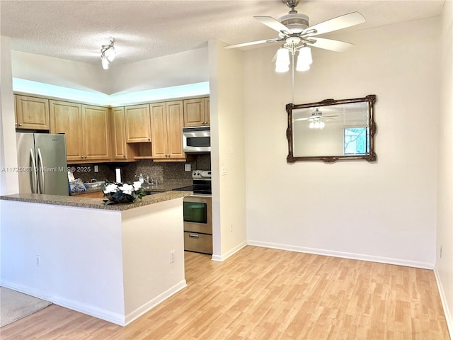 kitchen featuring backsplash, ceiling fan, light hardwood / wood-style floors, stainless steel appliances, and a textured ceiling