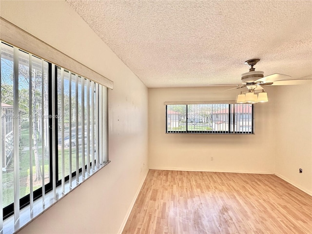 unfurnished room with wood-type flooring, ceiling fan, and a textured ceiling