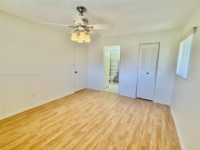 unfurnished bedroom featuring connected bathroom, a textured ceiling, and light wood-type flooring