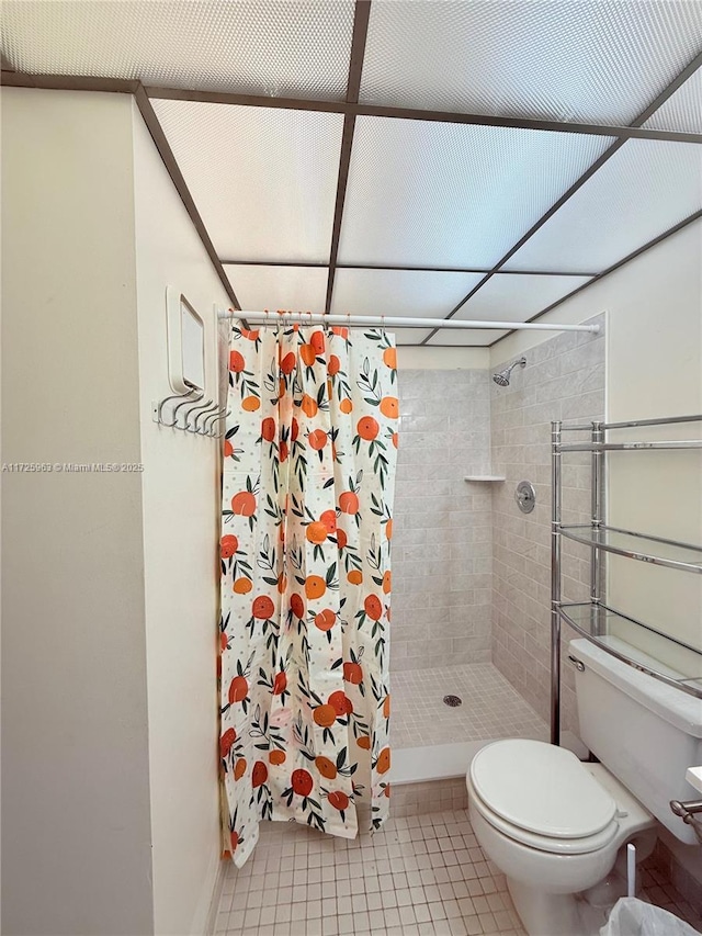 bathroom featuring tile patterned floors, toilet, and a shower with shower curtain