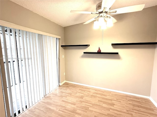 spare room featuring ceiling fan, light hardwood / wood-style flooring, and a textured ceiling