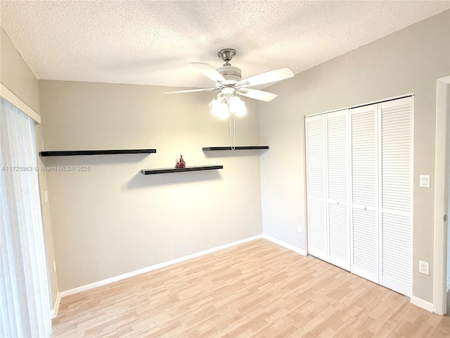 unfurnished bedroom featuring ceiling fan, light hardwood / wood-style floors, a closet, and a textured ceiling