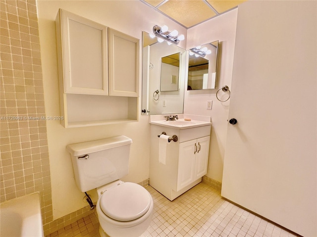 bathroom with tile patterned floors, toilet, vanity, and a washtub