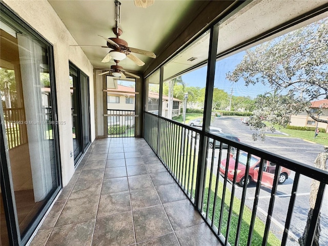 unfurnished sunroom with ceiling fan