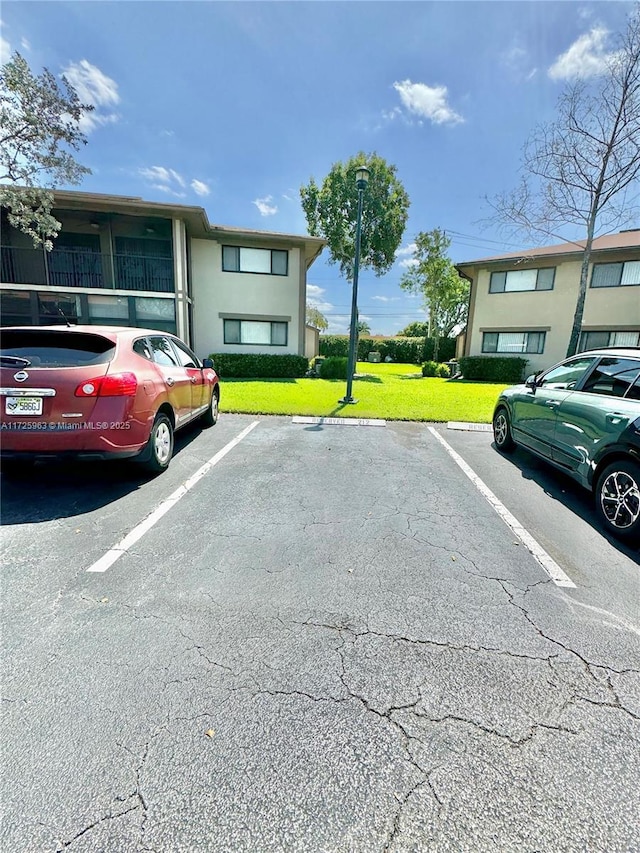 view of parking with a lawn