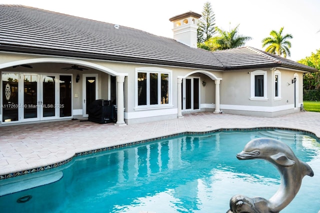 rear view of property with a tiled roof, french doors, a patio area, and a ceiling fan