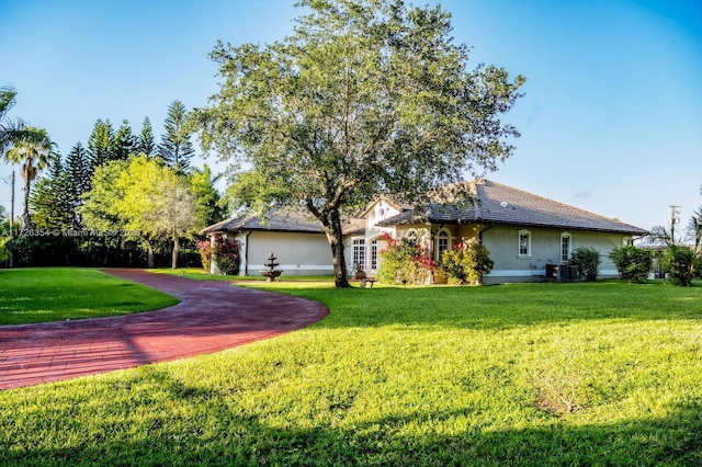 ranch-style home with a front yard, central air condition unit, and stucco siding