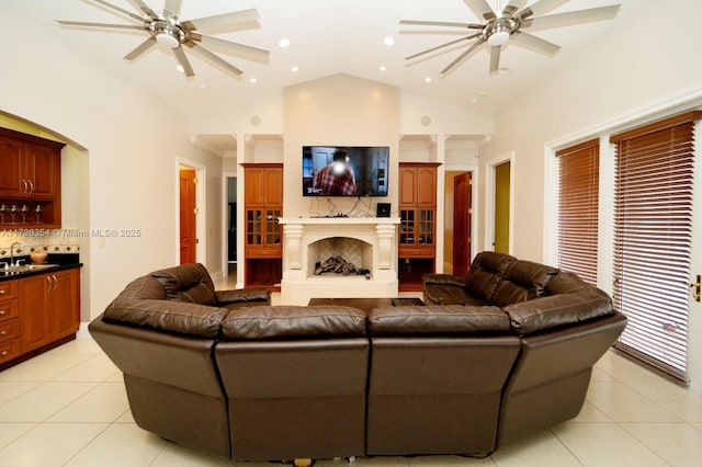 living room with light tile patterned flooring, ceiling fan, and a fireplace