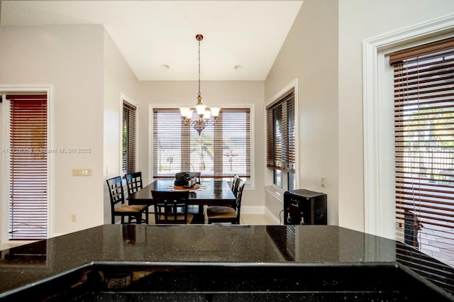 dining area with baseboards and an inviting chandelier