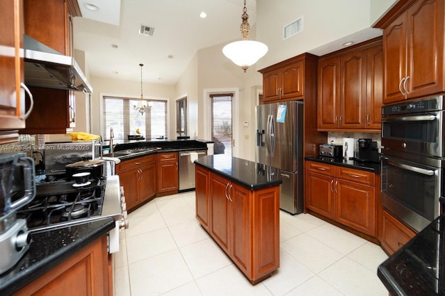 kitchen with appliances with stainless steel finishes, visible vents, a sink, and decorative light fixtures