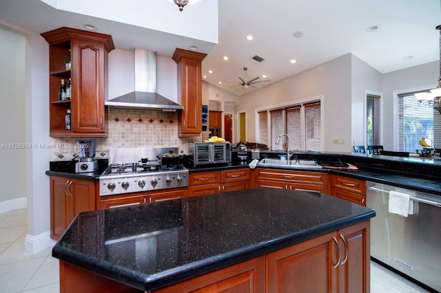 kitchen featuring light tile patterned floors, a sink, visible vents, wall chimney range hood, and appliances with stainless steel finishes