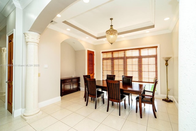 dining space with decorative columns, baseboards, visible vents, a tray ceiling, and crown molding