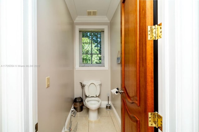 bathroom featuring toilet, visible vents, baseboards, tile patterned floors, and crown molding