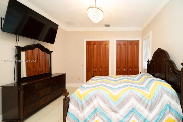 bedroom featuring crown molding, light tile patterned flooring, visible vents, and multiple closets