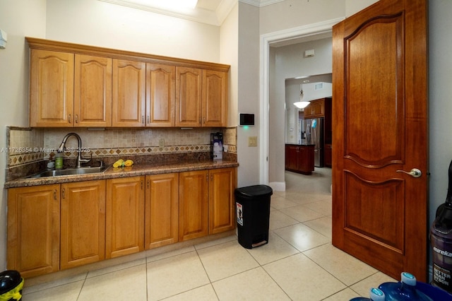 kitchen featuring decorative backsplash, stainless steel fridge with ice dispenser, crown molding, a sink, and light tile patterned flooring