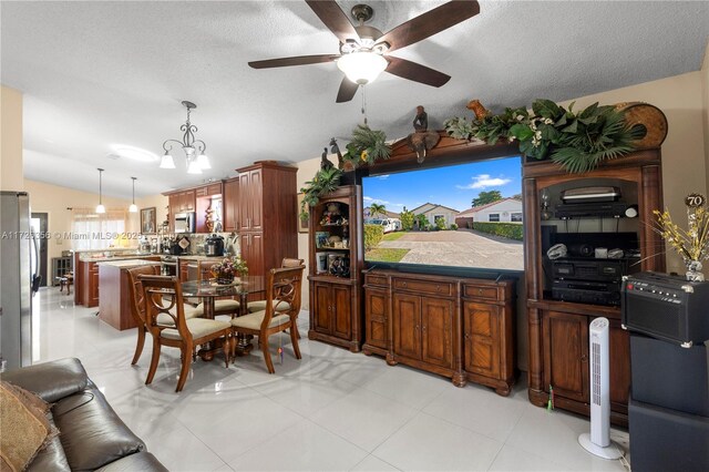 kitchen featuring lofted ceiling, a healthy amount of sunlight, ceiling fan with notable chandelier, and pendant lighting