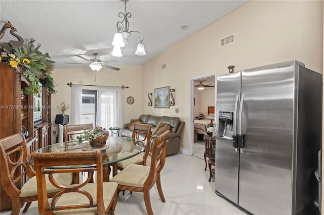 tiled dining space with a notable chandelier and a textured ceiling