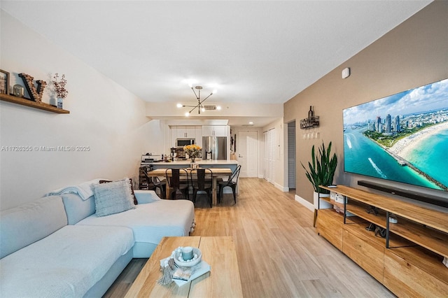 living room featuring a chandelier and light hardwood / wood-style flooring