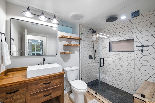 bathroom with a stall shower, toilet, and vanity