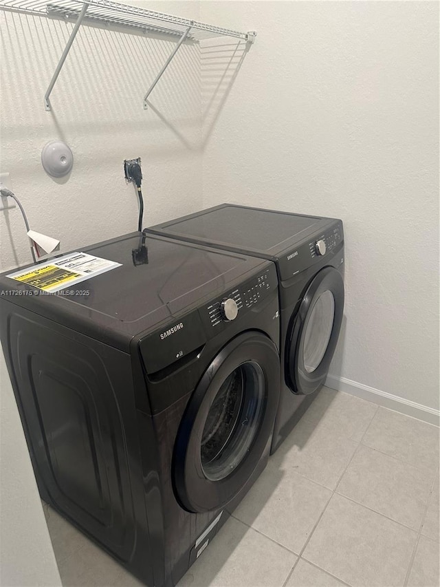 washroom featuring light tile patterned floors and washing machine and clothes dryer