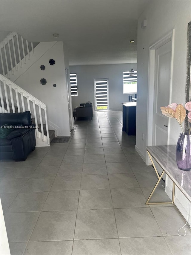 hallway featuring tile patterned flooring and an inviting chandelier