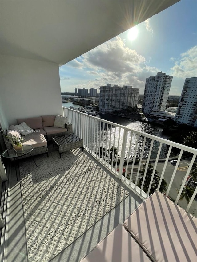 balcony with an outdoor hangout area and a water view