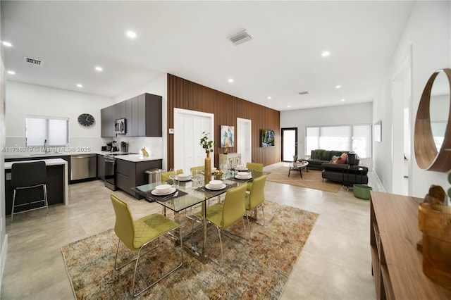 dining area featuring wooden walls and sink