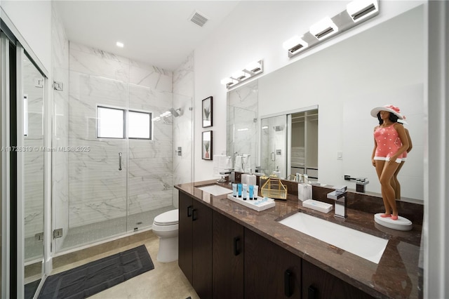 bathroom with toilet, vanity, and a shower with door