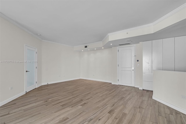 spare room featuring baseboards, light wood-style flooring, and crown molding